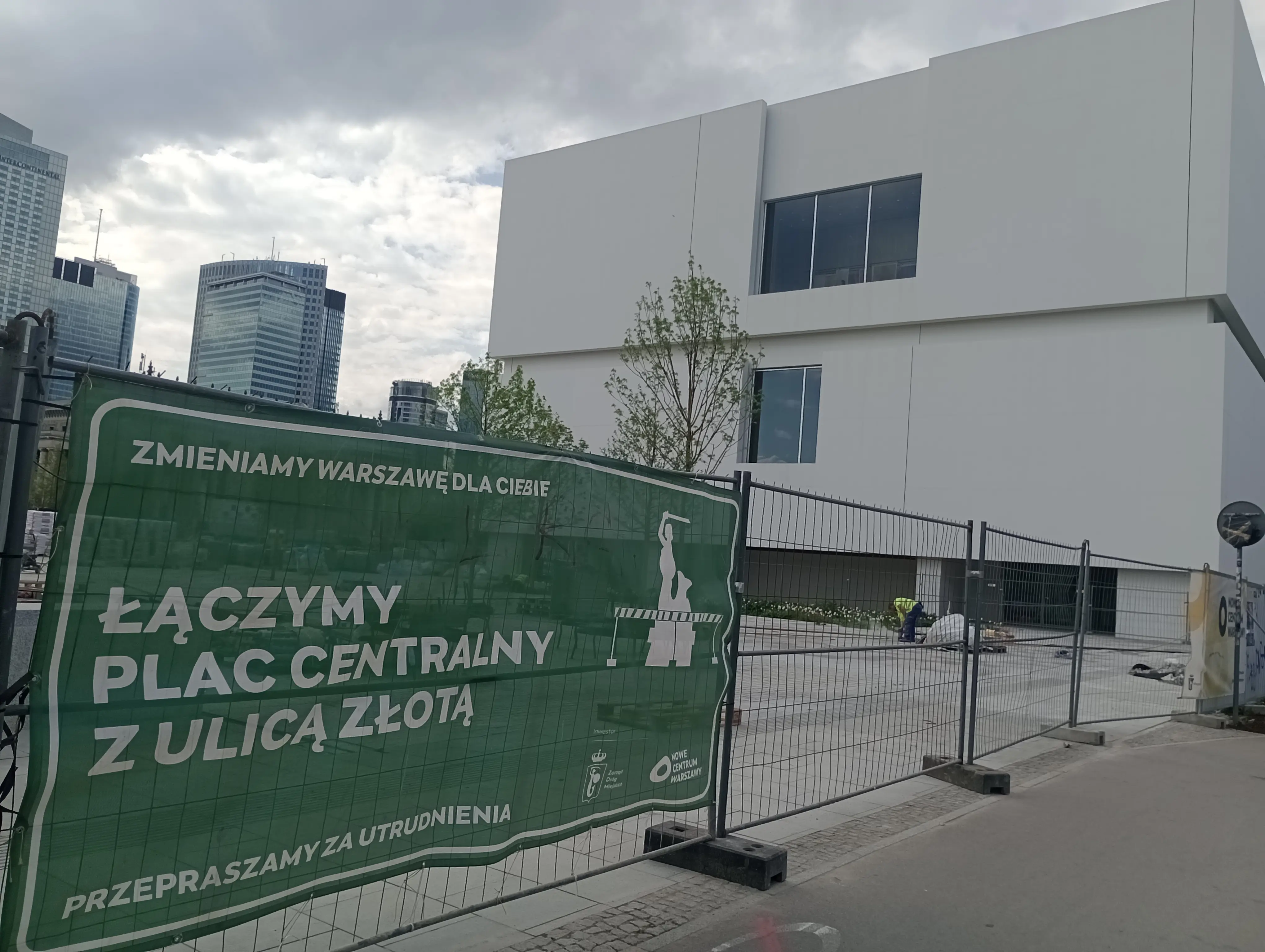 The museum next to a banner that informs about the construction of the Central Square in Warsaw