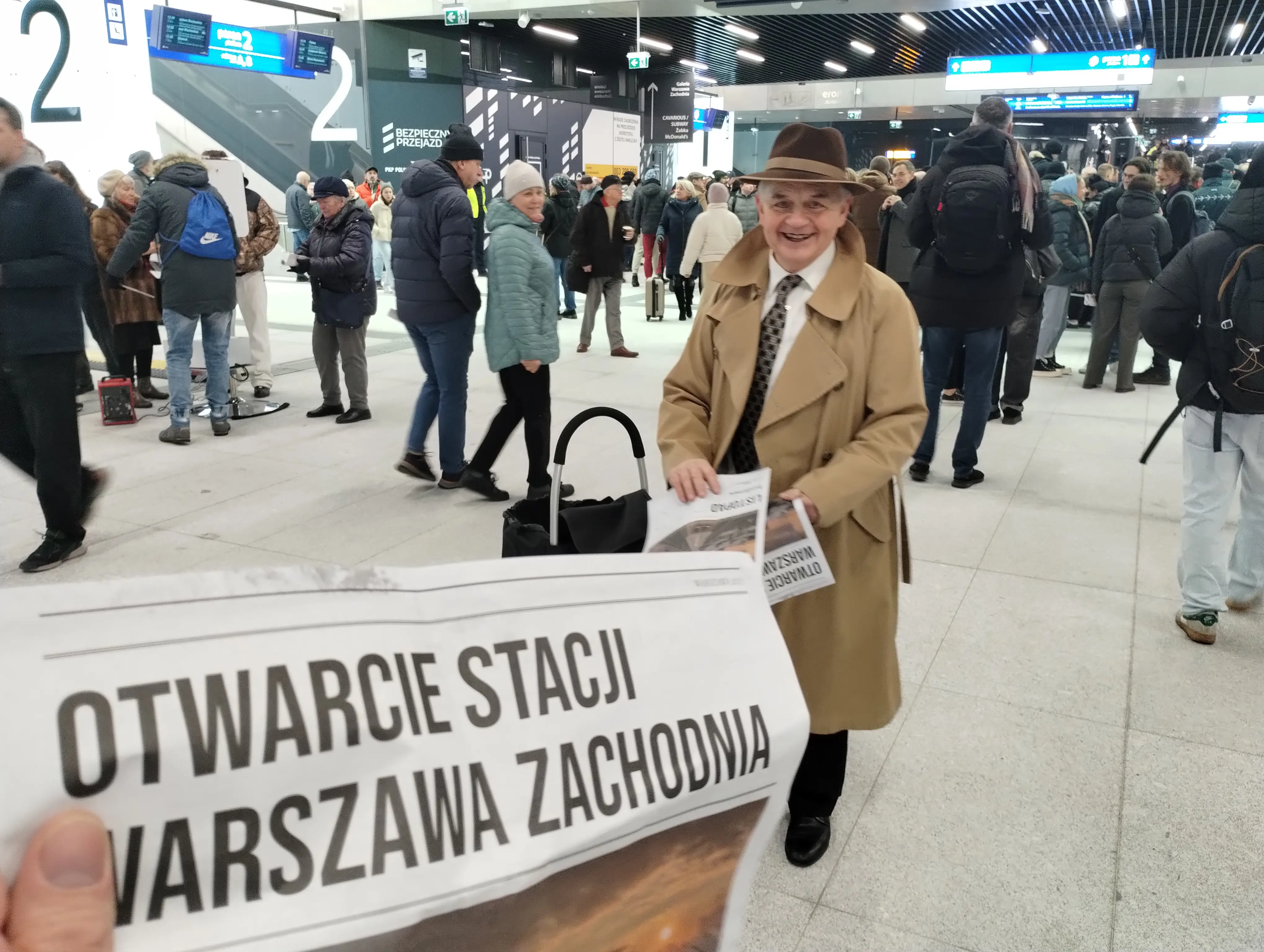 A guy giving the newspapers with the cover news 'Opening of Warsaw West Station'